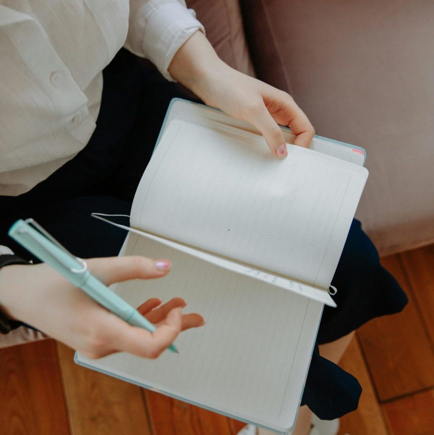 Déroulement d'un bilan de compétences : cette image montre une jeune femme en train de prendre les notes dans son cahier.